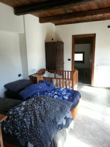 ein Schlafzimmer mit einem Bett mit blauer Decke in der Unterkunft AGRITURISMO IL RUNCH DI MAJRANO LUCA in Viù