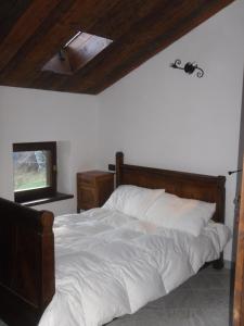 sypialnia z dużym łóżkiem z drewnianym zagłówkiem w obiekcie AGRITURISMO IL RUNCH DI MAJRANO LUCA w mieście Viù