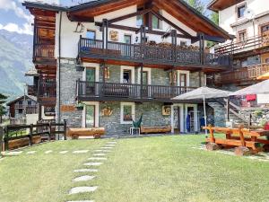 a large building with a balcony and a yard at Casa Lo Tzé in Valtournenche
