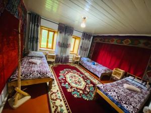 een slaapkamer met 2 bedden en een rood gordijn bij Guest house CBT Chon-Kemin in Shabdan