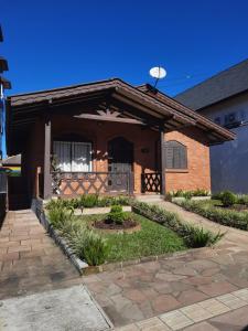 a home with a brick house with a patio at Casa Das Fontes - Centro in Gramado