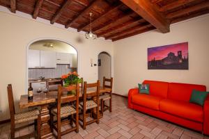 a living room with a red couch and a table at IBibiena - CASA NATALE BERNARDO TANUCCI in Stia