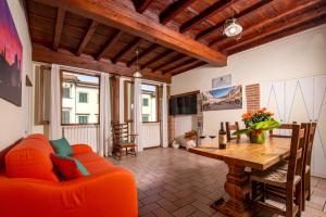 IBibiena - CASA NATALE BERNARDO TANUCCI في ستيا: غرفة معيشة مع أريكة برتقالية وطاولة خشبية