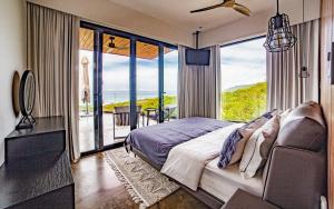 a bedroom with a bed and a view of the ocean at Casa Anna Santa Teresa in Santa Teresa Beach +23 photos