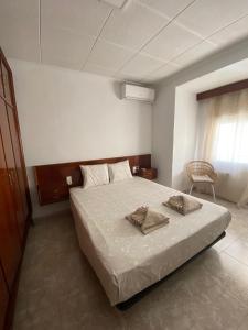 1 dormitorio con 1 cama con 2 toallas en Cozy Apartment in Centre of Alicante near Plaza de Toros, en Alicante