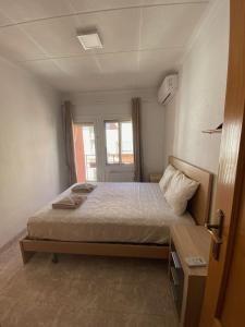 ein Schlafzimmer mit einem Bett in einem Zimmer mit einem Fenster in der Unterkunft Cozy Apartment in Centre of Alicante near Plaza de Toros in Alicante