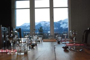 a table with wine glasses and a view of mountains at Auberge St P Vegetarien BnB in Saint-Pastous