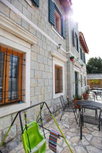 eine Terrasse mit einem Tisch und einem grünen Rasenmäher in der Unterkunft Villa Sol in Kaštela