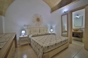 a bedroom with a bed with a mirror and a sink at Palazzo Zacheo in Gallipoli