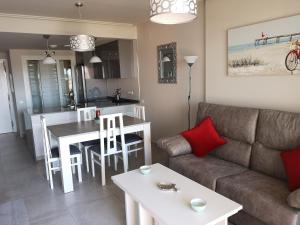 ein Wohnzimmer mit einem Sofa und einem Tisch in der Unterkunft Precioso Apartamento Planta Baja Junto a la playa in Isla Canela