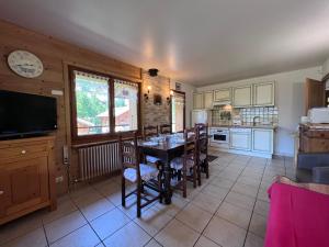 a kitchen with a table and chairs in a room at Petit Lutin - Chalet sur les pistes in La Clusaz