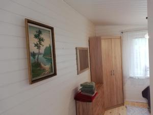 a room with a painting on the wall and a cabinet at Poilsio namelis po juodalksniais (Nemirseta) in Palanga