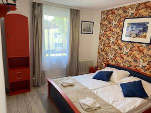 1 dormitorio con 1 cama grande con almohadas azules en Pension Victoria, en Unterburg am Klopeiner See