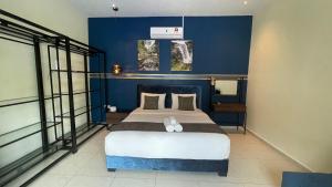 a bedroom with a large bed with a blue wall at Charis Pool Villa 2 - 3 bedroom with Private Pool in Bentong +13 photos
