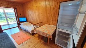 a room with a refrigerator and a table and a bed at Wellapartman Zamárdi in Zamárdi