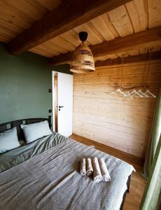 a bedroom with a bed with two towels on it at Chill House in Miežonys