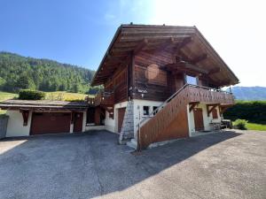 uma grande casa de madeira com uma grande entrada em Petit Lutin 1 - Studio dans chalet sur les pistes em La Clusaz