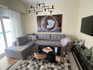 un soggiorno con divano e tavolo di MELMA PROPERTIES-AMAZONE-premium apartment in Piraeus center a Pireo