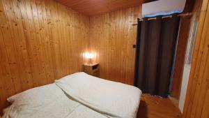 a bedroom with a bed and a lamp on a table at Wellapartman Zamárdi in Zamárdi
