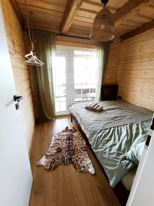 1 dormitorio con 1 cama en una habitación de madera en Chill House, en Miežonys