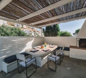 a patio with a table and chairs under a pergola at Villa Antigoni Serifos in Serifos Chora