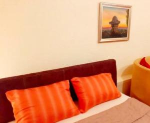 two orange pillows sitting on top of a bed at Apartman Sarajevo in Sarajevo