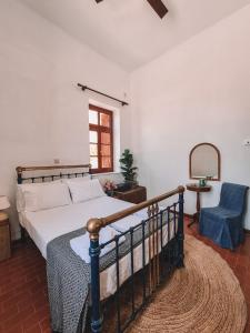 a bedroom with a bed and a chair and a mirror at Villa Antigoni Serifos in Serifos Chora