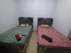 2 Betten nebeneinander in einem Zimmer in der Unterkunft Hotel Near Ramayana 3 in Pekalongan
