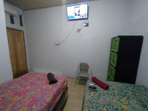 ein Schlafzimmer mit einem Bett und einem TV an der Wand in der Unterkunft Hotel Near Ramayana 3 in Pekalongan
