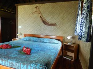 a bedroom with a bed with two roses on it at A Pueu Village in Pueu