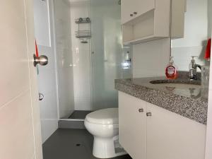 a white bathroom with a toilet and a sink at Céntrico mini departamento, moderno y acogedor in Lima