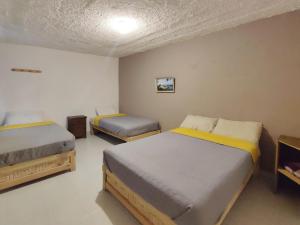2 camas en una habitación con 2 camas sidx sidx sidx sidx sidx sidx en Hostal IKAL en San Cristóbal de Las Casas