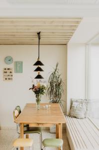 uma sala de jantar com uma mesa de madeira e cadeiras em Huisje Nummer Tien em Sint-Laureins