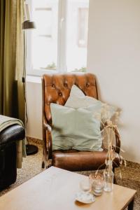Huisje Nummer Tien في سينت-لاورينس: أريكة جلدية بنية في غرفة المعيشة مع طاولة