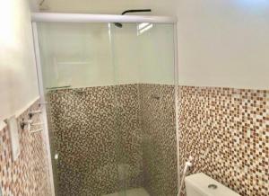 ein Bad mit einer Dusche und einer Glastür in der Unterkunft FlatStudio01 em condomínio residencial na Nova Betânia in Mossoró