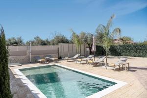 a swimming pool with lounge chairs and an umbrella at Villa Fanouris in Chania Town