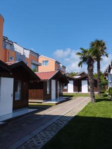 une rangée de maisons avec des palmiers dans une cour dans l'établissement Zafo Hotel, à Sinemorets