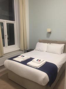 a bed with towels on top of it with a window at Keppels Head Hotel in Portsmouth