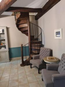 een woonkamer met 2 stoelen en een wenteltrap bij Chateau Le Vergel Authenac in Ginestas