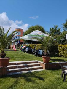 un parque con sillas y sombrillas en un parque en Zafo Hotel, en Sinemorets