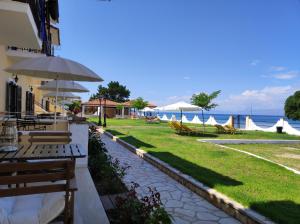 a patio with tables and chairs and the ocean at Thalassa Apartments & Studios in Kavos