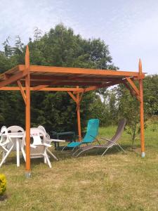 a wooden pavilion with chairs and tables in a field at la tente du commandant français 1954 pour nuit insolite in Arrest