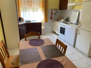 a kitchen with a table and a kitchen with a refrigerator at Relax Home/Lazit-Lak in Ebergőc