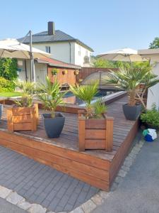 una terraza de madera con macetas. en Luxusferienwohnung-Mager, en Freyung