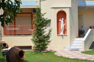 a statue of a woman on the side of a house at Villa Roxani in Limenas