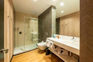 a bathroom with a toilet and a sink and a shower at Hotel Antonio II in Zahara de los Atunes +25 photos