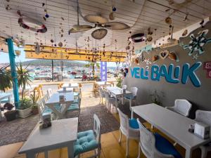 a restaurant with tables and chairs and a ceiling at Larimar Hotel Cesme in Çeşme