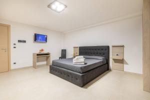 ein Schlafzimmer mit einem großen Bett und einem Schreibtisch in der Unterkunft Room Salento Palace 2 in Torre San Giovanni Ugento