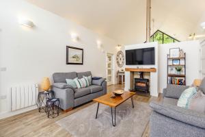 a living room with a couch and a tv at Forget Me Not Lodge in Bamburgh