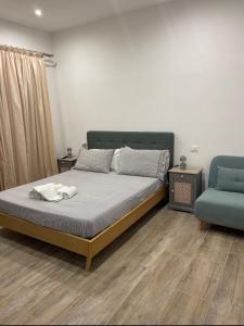 ein Schlafzimmer mit einem Bett und einem blauen Stuhl in der Unterkunft VILLA MATILDA luxury B&B in Ischia